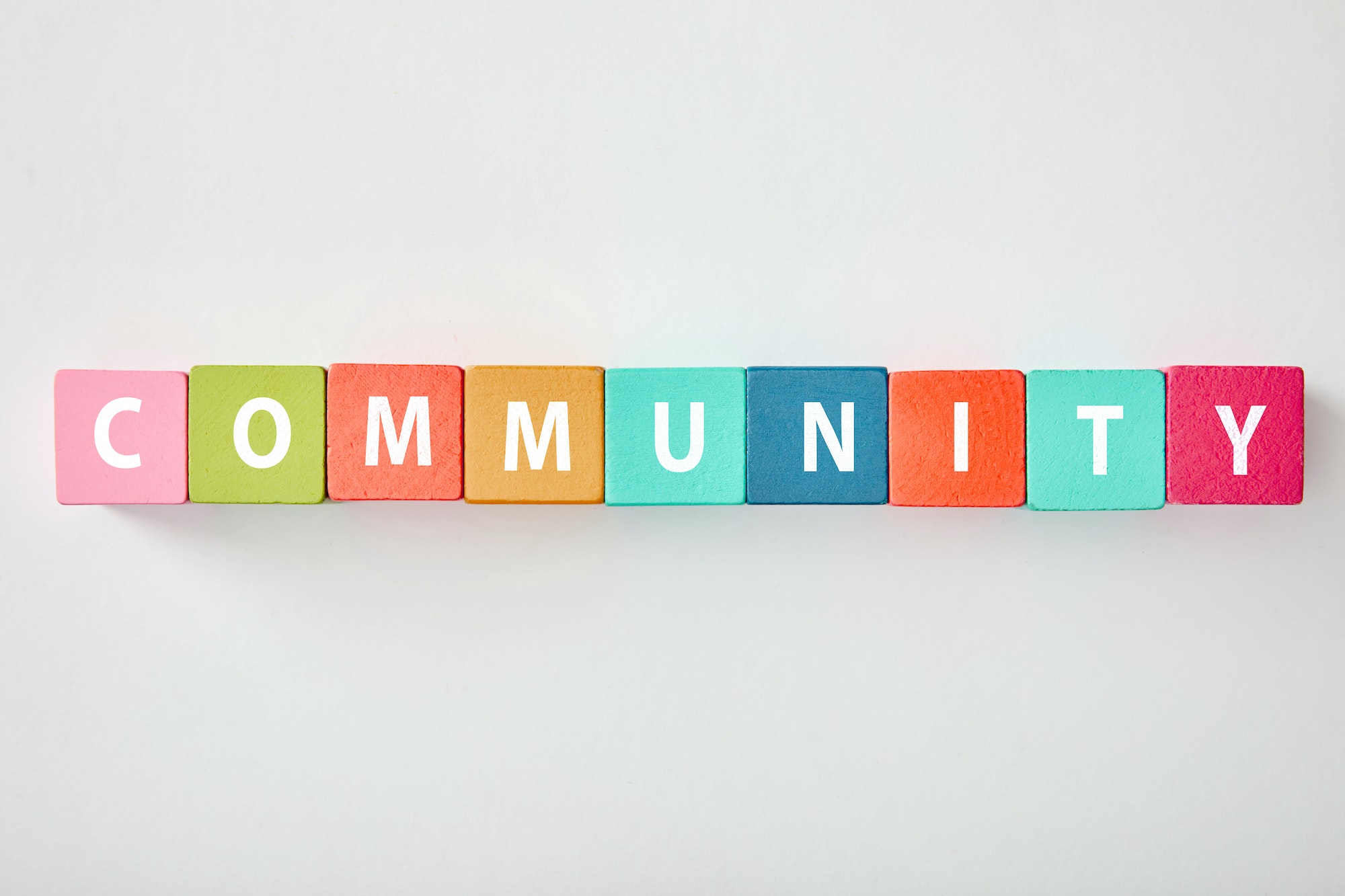 top view of community lettering made of multicolored cubes on grey background